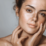 Attractive young woman with beautiful skin seen from bare shoulders up