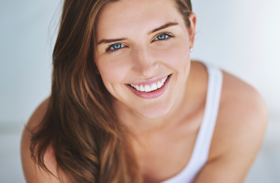 Woman in tank top looking up and smiling
