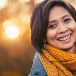 Brunette woman smiling after getting dermal fillers.