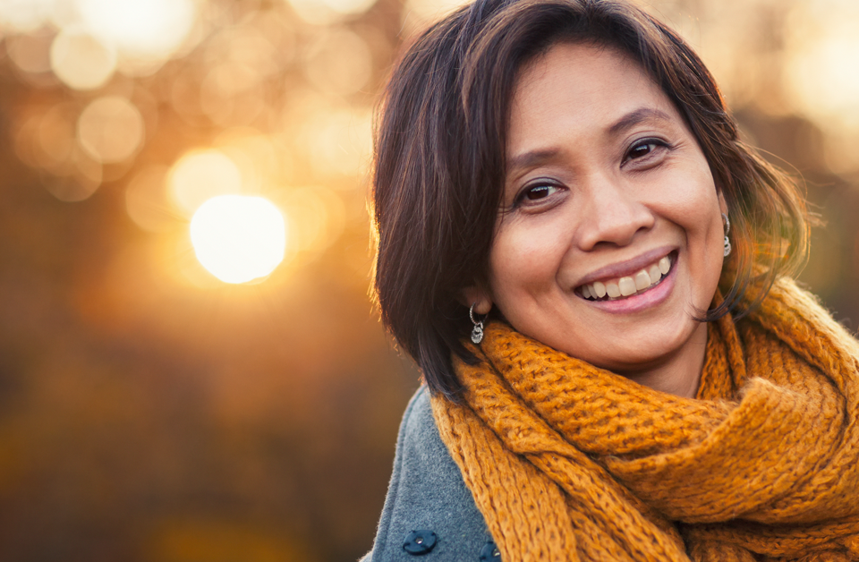Brunette woman smiling after getting dermal fillers.