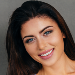 Woman from shoulders up smiling with head slightly tilted
