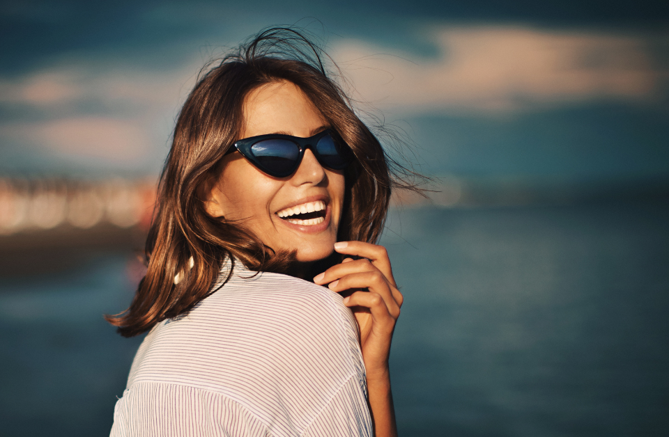 Woman in sunglasses looking back and smiling