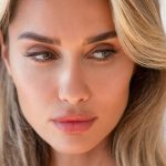 blonde hair woman showing off her new pout after her lip filler procedure (MODEL)