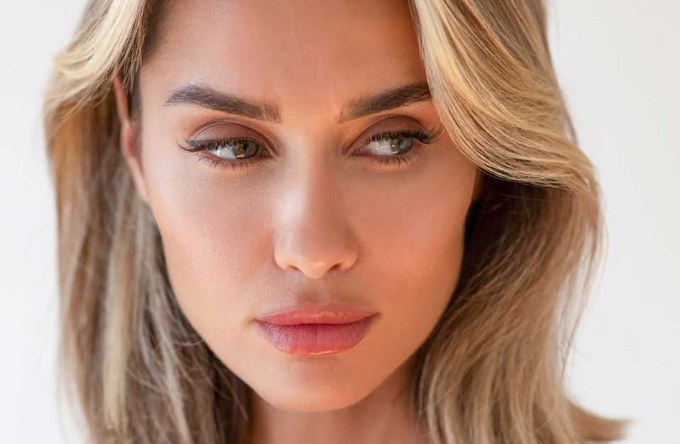blonde hair woman showing off her new pout after her lip filler procedure (MODEL)